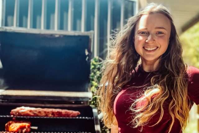Kate Brown, Burning Brisket founder standing in front of pellet smoker during trial