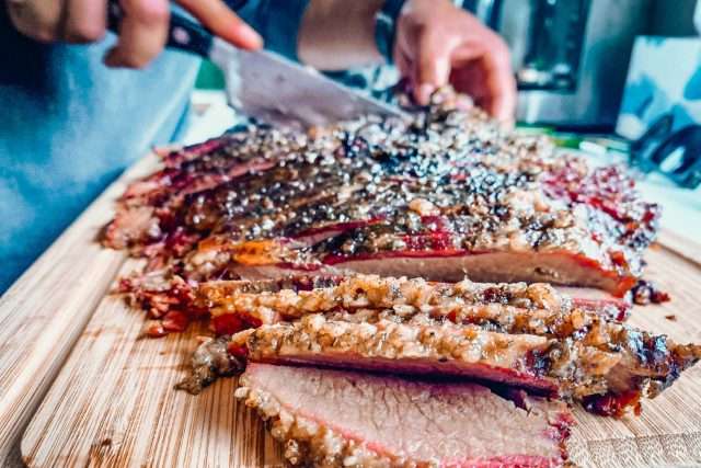 Slicing a salt ad peppet smoked brisket cooked by Kate Brown, Burning Brisket founder