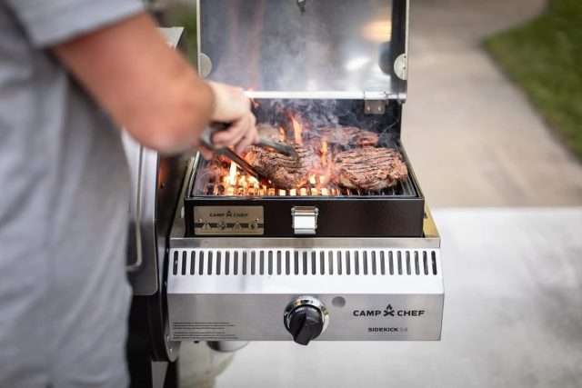 Camp Chef Woodwind Pro 24 with sidekick attachment grilling steaks